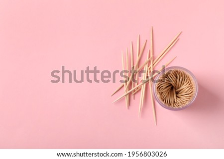 Wooden toothpicks and holder on pink background, flat lay. Space for text Royalty-Free Stock Photo #1956803026