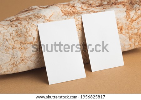 Business card against bright sand stone. Mock up.