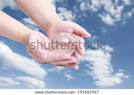 earth globe in hands in blue sky background