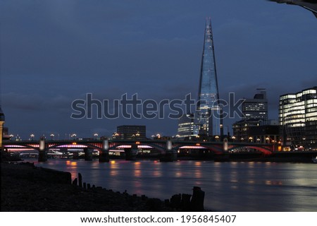 View of the Shard in twilight with lights reflected in Thames river