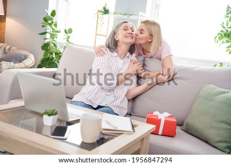 Photo of cheerful positive family daughter kiss mom good mood gift women day indoors inside house home