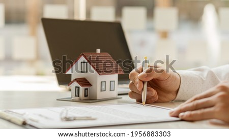 Real estate brokerage contracts for sale and rent with a house on the table in the office. Royalty-Free Stock Photo #1956883303