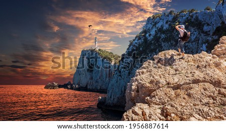 Fantastic Colorful sunset over the Lighthouse on the cliff Stunning picturesque vivid landscape over the Ionian Sea. Lefkada island. Greece. Popular travel and hiking destination and photography place