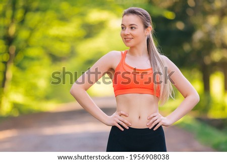 Portrait of fitness young woman outdoors in the park. Sportswoman resting. Portrait of happy fitness woman. Copy space