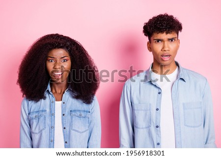Photo of two impressed unsatisfied dark skin persons open mouth staring camera isolated on pink color background