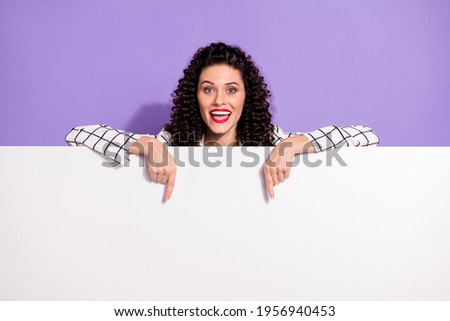 Photo of young excited girl happy positive smile indicate finger empty space ad promo banner isolated over violet color background