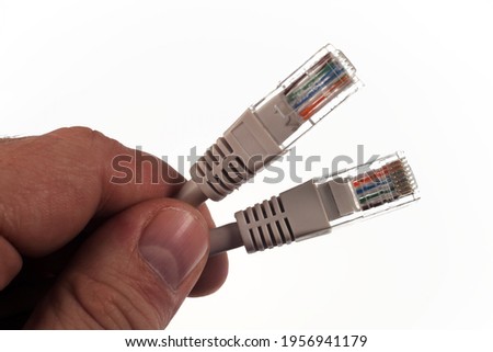 Pair of twisted Ethernet LAN network cables, in the hand of the master, Isolated on white background. 