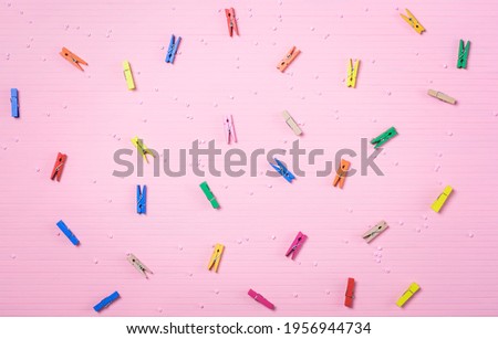 Multicolored little clothespins on a pink background. Education, school, business concept. clothespins, stationery