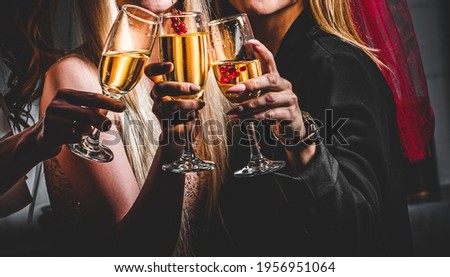 Women's hands with glasses of champagne wine. Clinking glasses of champagne in hands