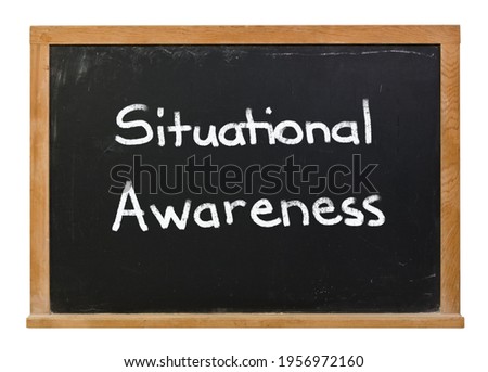 Situational Awareness written in white chalk on a black chalkboard isolated on white Royalty-Free Stock Photo #1956972160