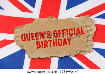 Holidays of the UK. Against the background of the flag of Great Britain lies cardboard with the inscription - Queens Official Birthday