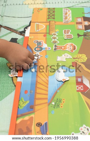 a toddler playing magnetic toy animal farm
