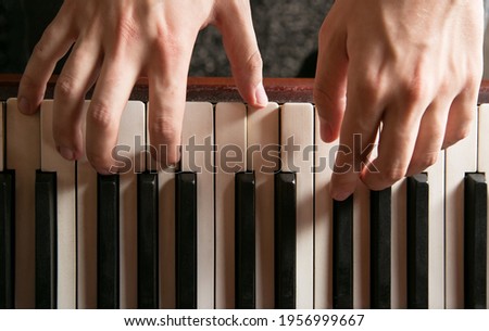 Close-up of hands playing the piano Royalty-Free Stock Photo #1956999667