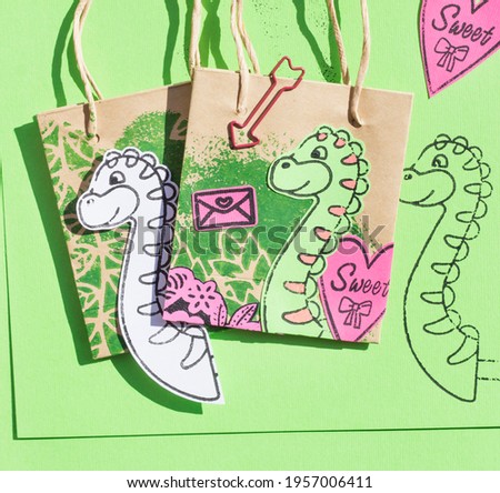 Drawing of a dinosaur made with a template. Children's stamping with stamps. Craft with colored cardboard. 
