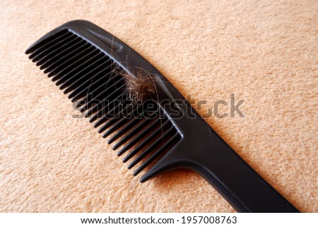 A comb with matted hair lies on a towel