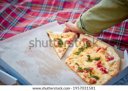 Boy's hand is taking a pizza slice. Fast food concept.  Improper nutrition concept. Copy space
