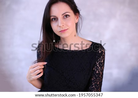 Portrait of a cute young romantic girl with black hair and a beautiful smile fashionable model
