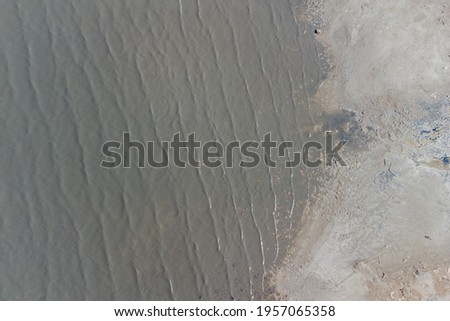 A stone spit and wooden pillars on the surface of the Kuyalnik estuary. Helicopter view