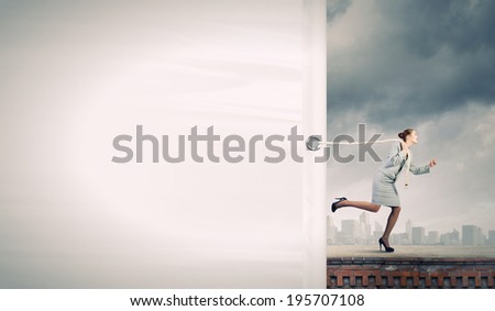Young businesswoman running and pulling white blank banner