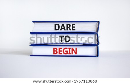 Dare to begin symbol. Books with words 'Dare to begin'. Beautiful white background. Business, dare to begin concept, copy space.