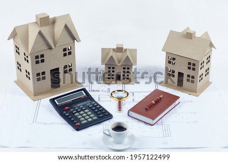 Cardboard houses calculator pen notepad magnifier coffee cup blueprints isolated on white background