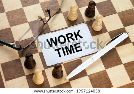 Business card with text Work Time on a chess board with pen and eyeglasses. Concept photo