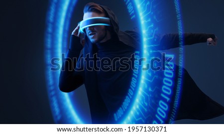 Man on dark virtual reality background. Guy using VR helmet. Augmented reality, future technology, game concept. Blue neon light. Futuristic holographic interface to display data.