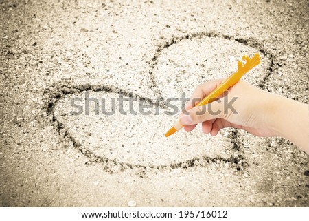 Hand writing with pen on sand background