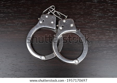 handcuffs on the table, arrest imprisonment closeup . Royalty-Free Stock Photo #1957170697
