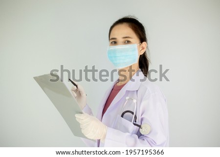 Asian women doctor wear surgical mask holding clipboard 