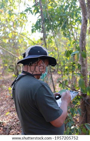 Botanists are taking notes. And take pictures of the plants found in the tropical forest A biologist researching the forest Botanists study new flowering plants.