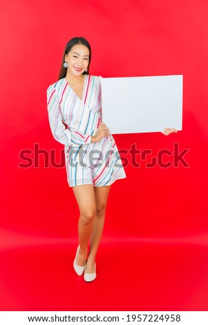 Portrait beautiful young asian woman with empty white billboard on red color