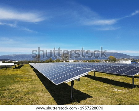 solar panels solar energy in a green meadow and blue bright sky spring season