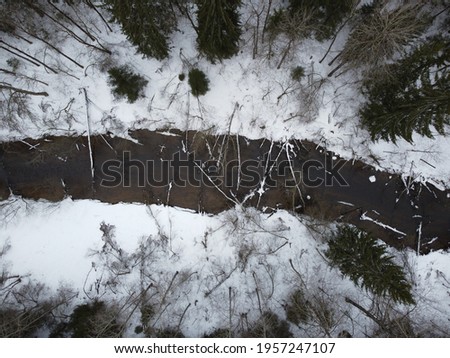 small forest river in winter aerial photo.