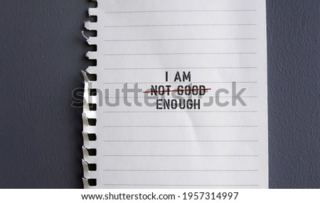 torn paper note with text I AM NOT GOOD ENOUGH with red crossing on NOT GOOD , concept of self worth , stop striving for approval, more valid , more loved or validation , you are good enough Royalty-Free Stock Photo #1957314997