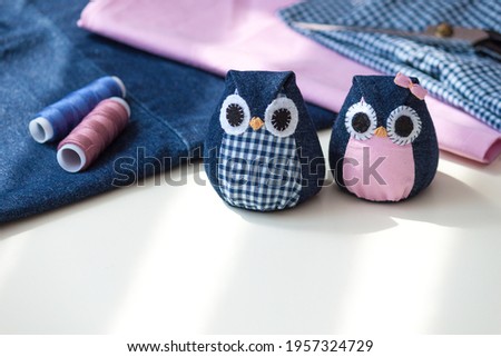 Hand made owls. Craft tools and materials on the table.