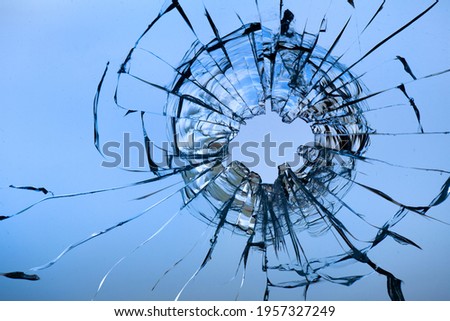 hole from a ball in the glass on a background of sky