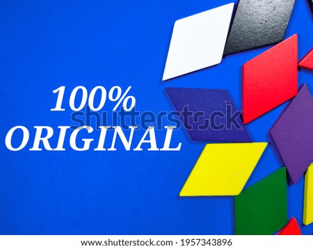 Colorful pieces of wood on blue background with text 100% ORIGINAL.Business concept.