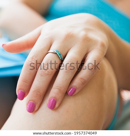 Female hand with silver ring with larimar stones, close up photo with selective focus