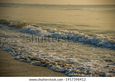 Background view of sunset at the coastline with the water surface at sunset.