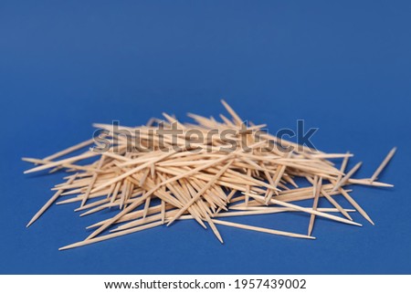 Pile of wooden toothpicks on blue background
