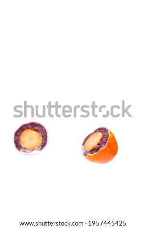 Orange candy with peanuts inside cut in half on a white background isolated.