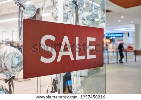 New Year's sale time at european shopping center. Christmas promotions in clothing store. Seasonal sale, holiday discounts in shopping mall.