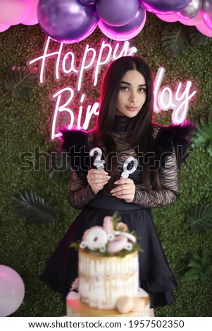 Iranian 20 years old beautiful girl's birthday with happy birthday neon sign an green wall