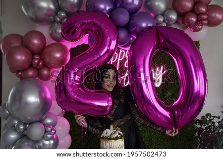 Iranian 20 years old beautiful girl's birthday with happy birthday neon sign an green wall