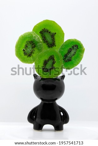 Bright green candied kiwi fruit in a jug with horns. Dried fruits. Candied kiwi.