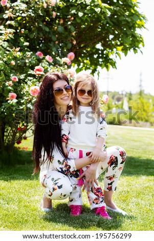 Beautiful mother and daughter relaxing on grass 