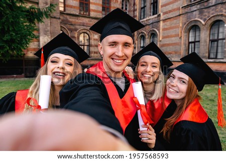 University graduates in graduation gown and cap, diploma in hand, celebrating academic success at the graduation ceremony. Take a photo for memory.
