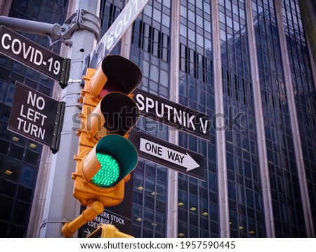 Stop Covid-19 concept. NYC Wall street yellow traffic light with green light, black pointer guide one way to Russian vaccine Sputnik V. No turn to coronavirus and pandemic