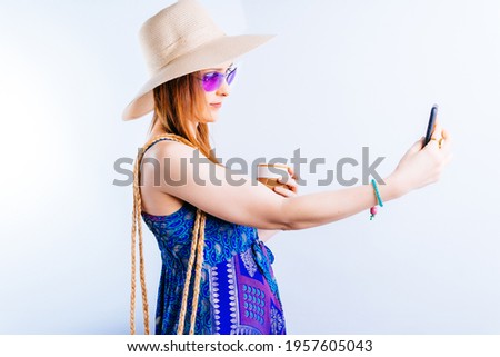 beautiful young woman in summer hat cup of coffee and dress taking a selfie on white background